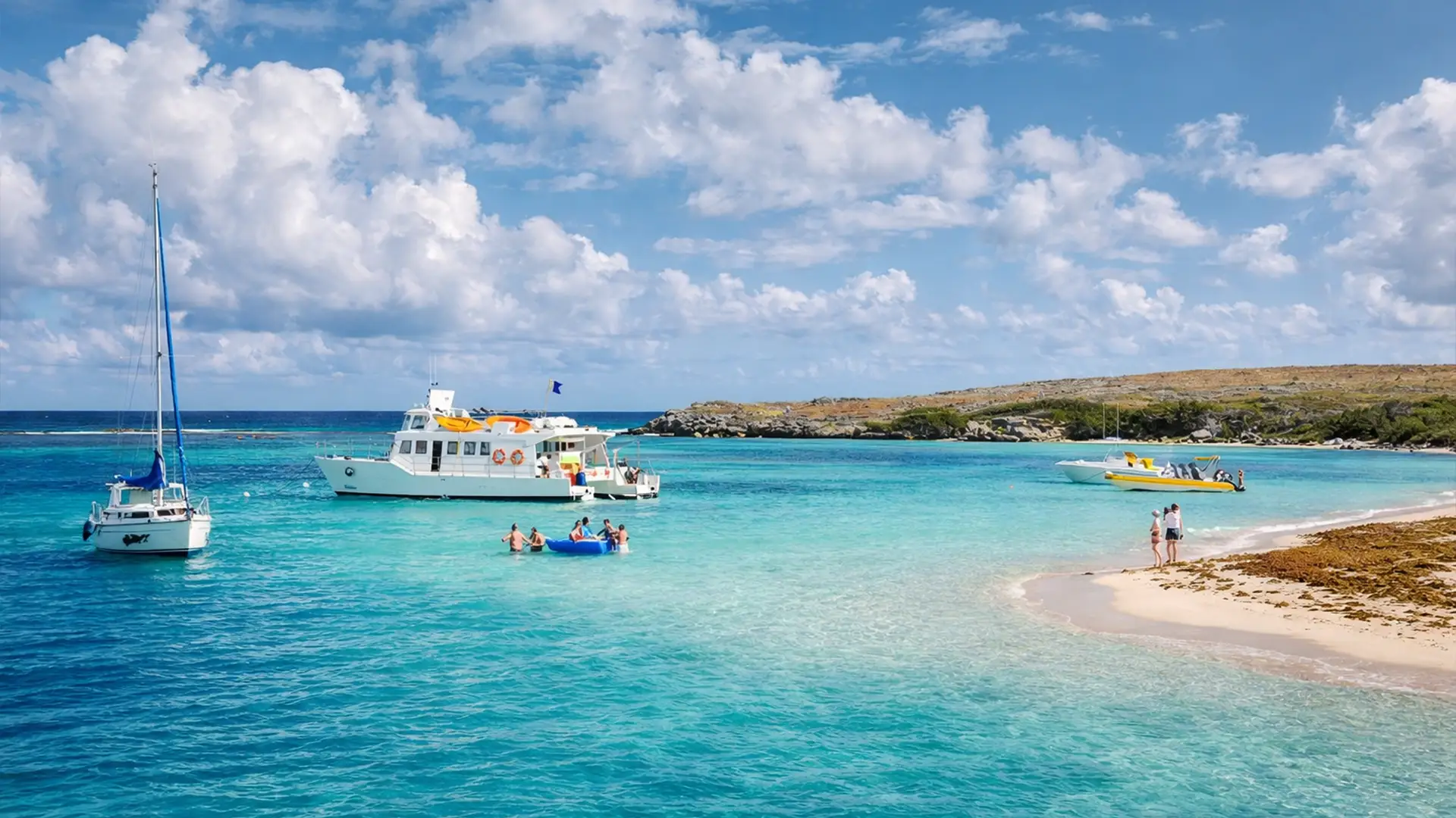 Mouillage du maxi-catamaran à moteur dans le lagon de Petite-Terre, eaux turquoise et plage de sable blanc