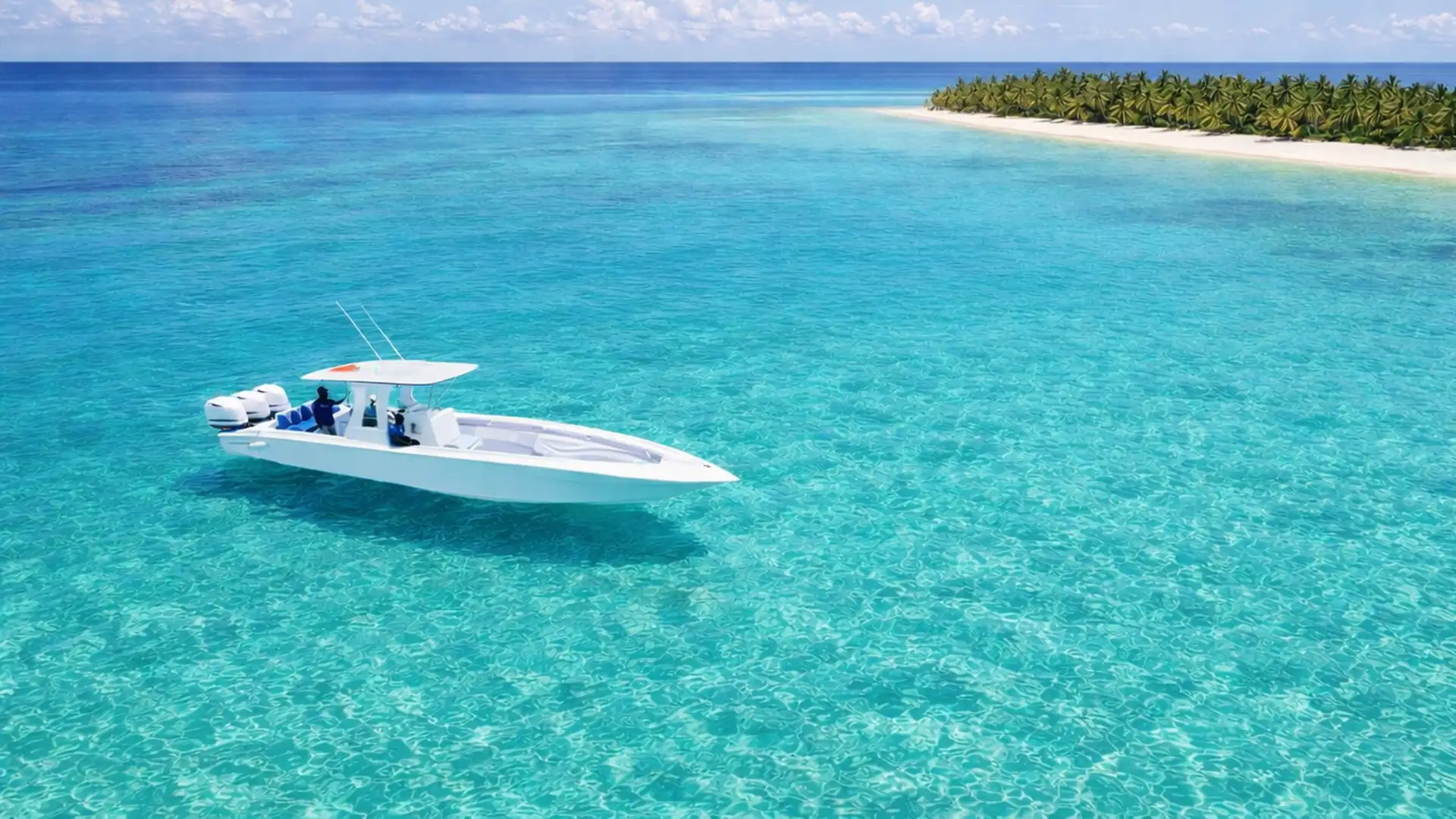 Speedboat naviguant sur des eaux turquoise lors d’une excursion en Guadeloupe, face à un îlot bordé de palmiers