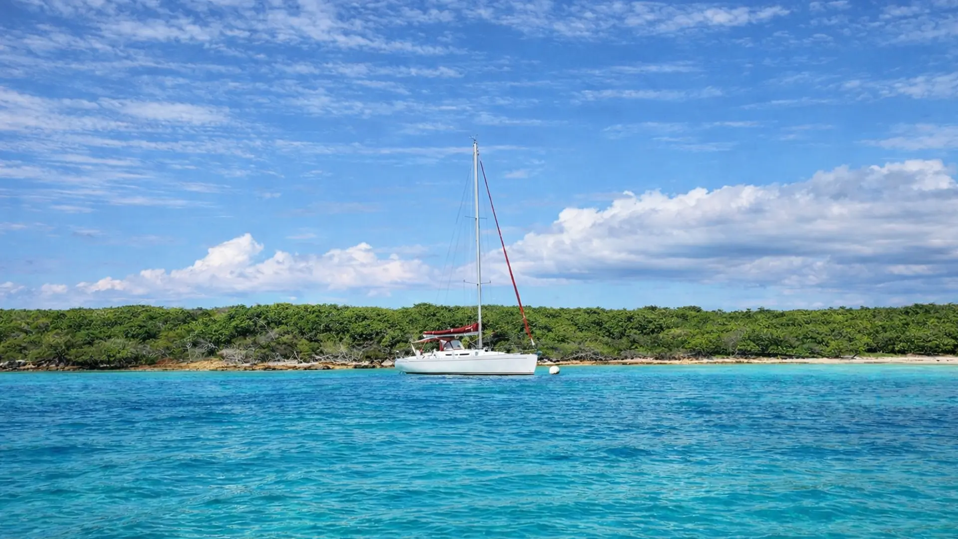 Voilier privatisé au mouillage dans les eaux turquoise de Guadeloupe lors d’une excursion, croisière ou mini-croisière vers les îles