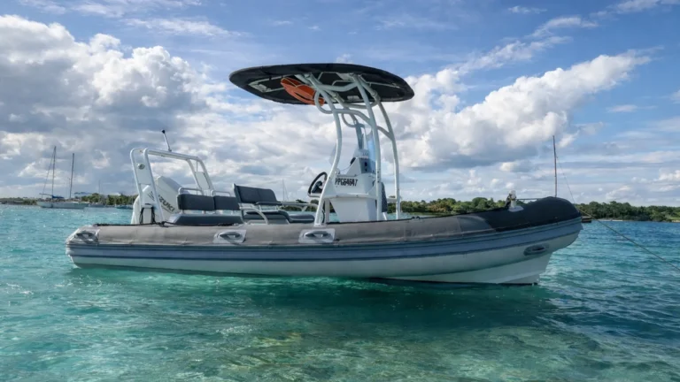 Bateau semi-rigide dans une eau turquoise en Guadeloupe avec lagon et voiliers à l’horizon