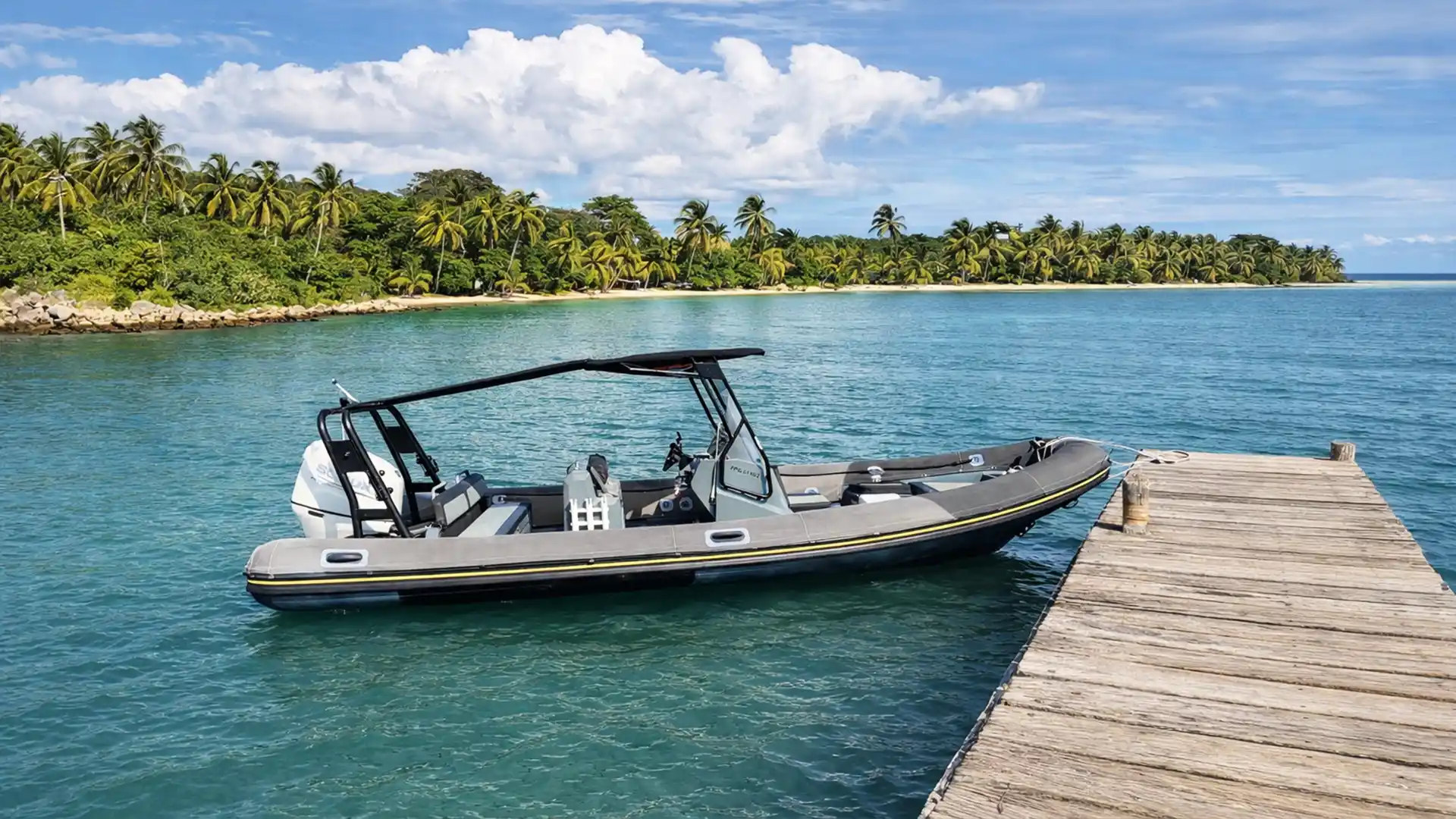 Bateau moteur Highfield Patrol 700 amarré à un ponton dans le lagon turquoise de Saint-François en Guadeloupe.