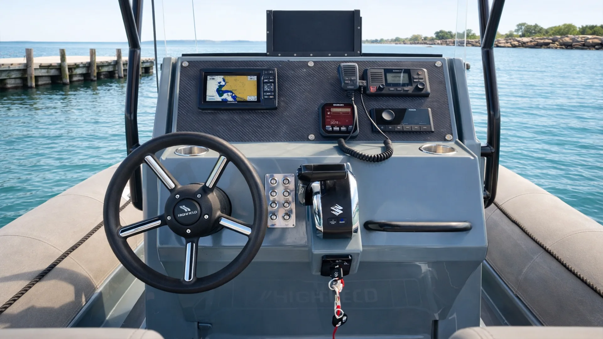 Poste de pilotage d’un bateau moteur Highfield Patrol 700 avec volant, GPS et commandes, prêt à naviguer depuis Saint-François en Guadeloupe.