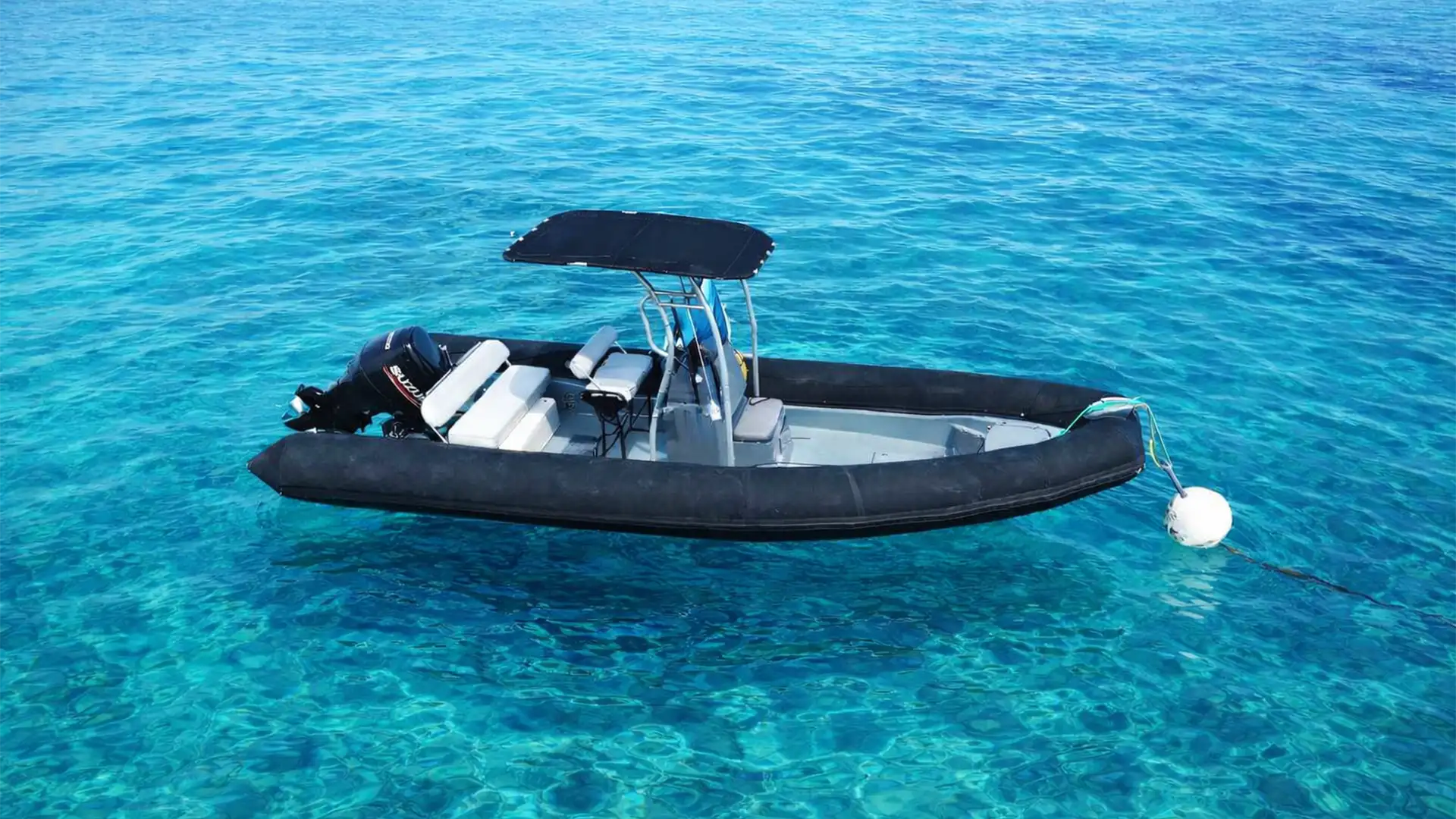 Bateau semi-rigide amarré dans l’eau turquoise au large de Saint-François en Guadeloupe, idéal pour une location de bateau et explorer le lagon.