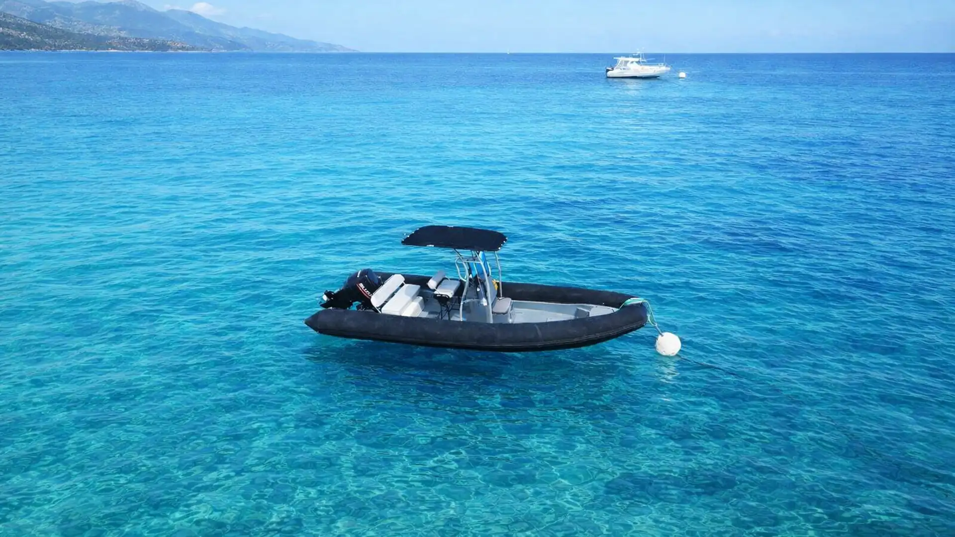 Bateau semi-rigide amarré dans l’eau turquoise au large de Saint-François en Guadeloupe, idéal pour une location de bateau et explorer le lagon.