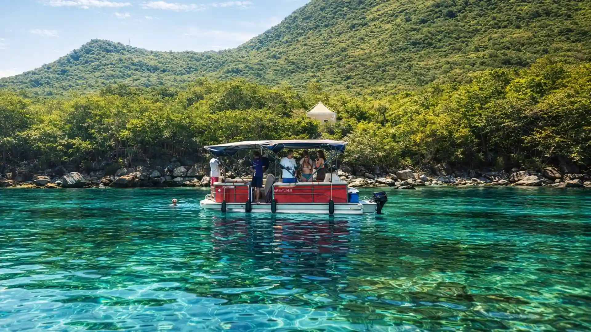 Pontoon Boat au mouillage aux Saintes avec baignade, au pied du Pain de Sucre lors d’une sortie détente en mer