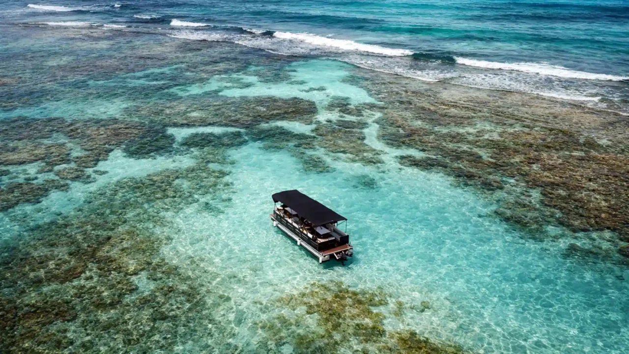 Lounge Boat en Guadeloupe à l'arrêt sur un lagon turquoise, bateau festif privé pour Boat Party et BBQ en mer