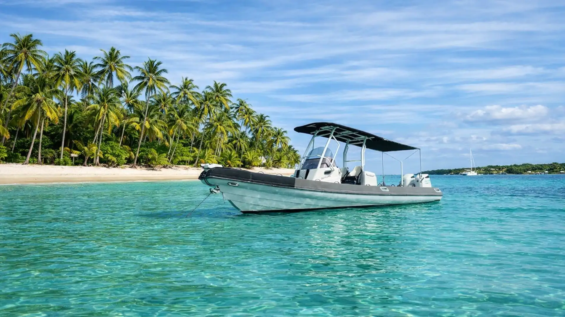 Bateau confortable disponible à la location ou en excursion privative en Guadeloupe, au mouillage dans les eaux turquoise de l’îlet Gosier.