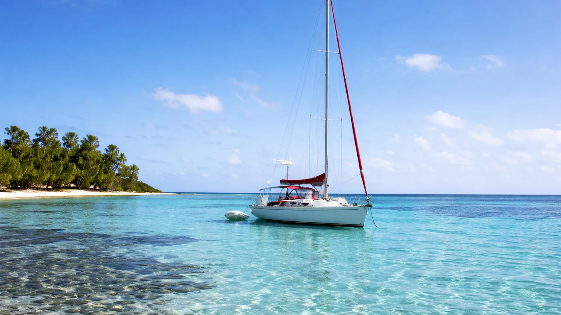 Voilier ancré dans un lagon aux eaux turquoise en Guadeloupe, utilisé pour des excursions à la journée vers Petite-Terre et Marie-Galante, ou des croisières dans l'archipel Guadeloupéen.